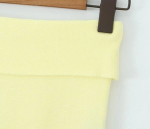 Primer plano de tela de punto amarillo pálido con puños acanalados y textura detallada