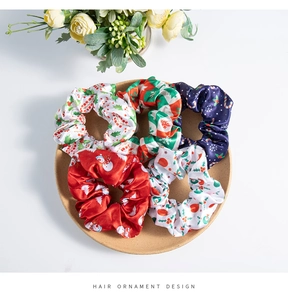 Detailed top view of five festive Christmas pattern hair scrunchies on a tray