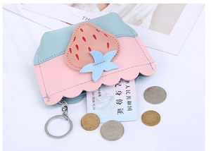 Detail of strawberry shaped coin purse with pink and blue leather stitching and metal ring