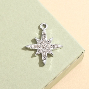 Macro detail of silver snowflake star pendant with sparkling white crystals for DIY jewelry