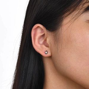Minimalist silver water drop stud earrings in polished stainless steel on female model