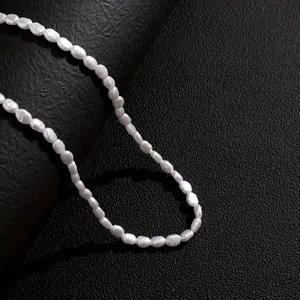 Baroque irregular white pearl bracelet for men on textured black surface