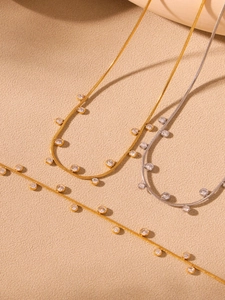 Gros plan détaillé de colliers à chaîne serpent en or 18k et argent avec glands zircons