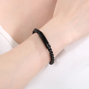 Close-up of a men's black stainless steel wheat chain bracelet worn on a wrist
