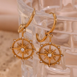 Gros plan d'une boucle d'oreille étoile boussole dorée 18 carats avec cristaux