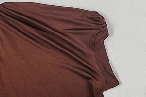 Detail of dark brown satin dress showing elegant shoulder pleats and glossy texture