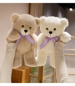 Detail of soft plush teddy bears in brown and white with purple polka dot bow ties