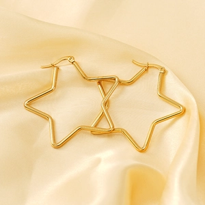 Créoles minimalistes en forme d'étoile plaquées or 18 carats sur un tissu en soie jaune