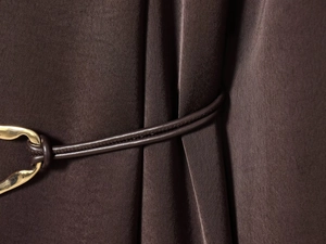 Détail de la taille avec ceinture en cuir marron foncé et boucle dorée sur robe en satin