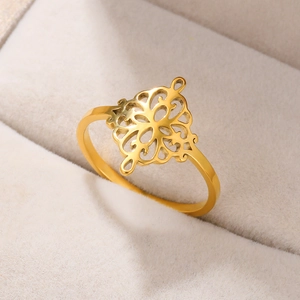 Macro view of gold plated hollow heart ring with diamond pattern on white jewelry box