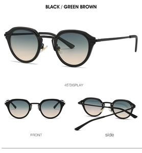 Detail view of oval retro sunglasses with black frames and green-brown gradient lenses