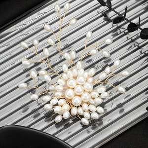 Elegant gold pearl tree brooch pins with sparkling white floral details on metallic tray