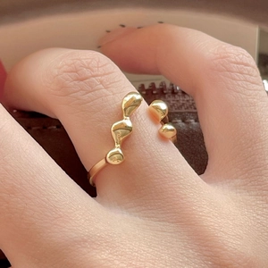 Artistic golden irregular organic ring in minimalist style worn on a finger