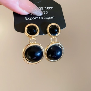 Detail of vintage round resin pendant earrings in gold finish with 925 silver posts
