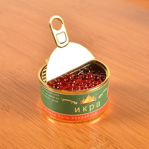 Macro shot of miniature red caviar tin prop with Russian label on wooden background