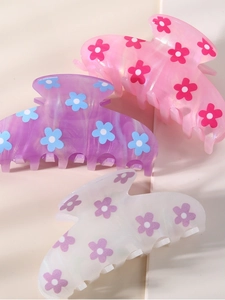 Close-up of pink, purple, and white acetate hair claws with colorful floral patterns