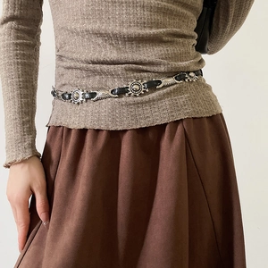 Close-up of black leather belt with silver sunburst metal concho charms and Western style