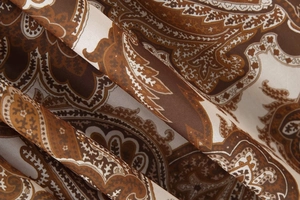 Gros plan du tissu imprimé paisley aux tons marron et beige pour robe longue