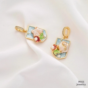Detail of square gold earrings with blue enamel, Baroque pearl, and floral accents