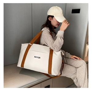 Detail of the large canvas gym bag showing sturdy brown straps and HAYUN front pocket
