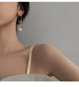 Detailansicht goldener Ohrhaken mit weißer Perle, am Ohr eines Models getragen