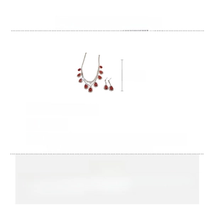 Detailed view of silver copper necklace and earrings set with red teardrop rhinestones