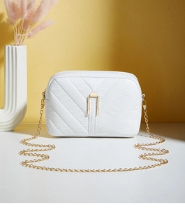 Detailed view of white quilted crossbody bag with gold chain and metal buckle closure