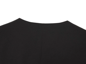 Detail shot of the neckline on a black double-breasted vest with fine textile texture