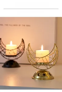 Detail of moon-shaped metal candle holders with hollow star and moon patterns in black and gold