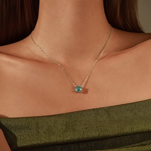 Élégant collier en or avec un pendentif rond bleu vif sur une chaîne délicate et fine