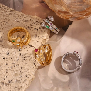 Detail of spiral rings with colorful zircon inlays on gold and silver metal finishes