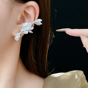 Close-up of silver lotus flower earrings worn on a model with elegant metallic luster