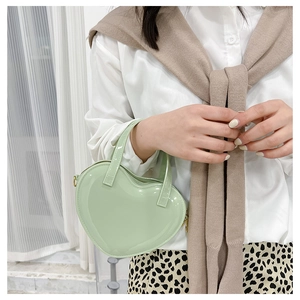 Mint green heart-shaped jelly bag shown as a crossbody purse on a fashion model