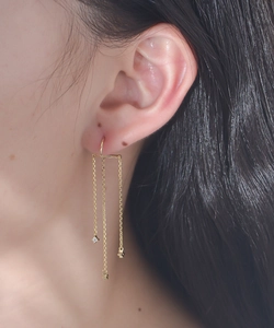 Detail of gold long chain tassel earrings with tiny sparkling cubic zirconia stones