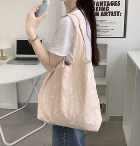 Lace canvas tote bag with white plant embroidery shown in a lifestyle office setting