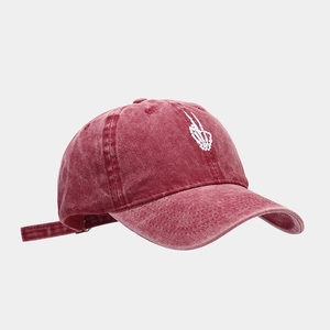Detail of white skeleton hand embroidery on burgundy washed vintage baseball cap