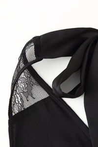 Dettaglio delle cuciture in pizzo nero e dei lacci sulla nuca dell'abito aderente sexy