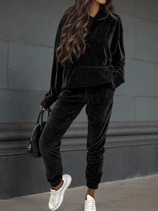 Detail of premium black velvet hoodie and jogger set texture on a female model