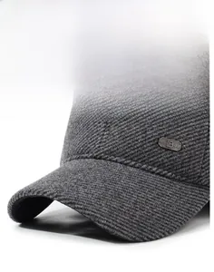 Close-up of dark grey winter baseball cap with thick tweed texture and metal plaque detail