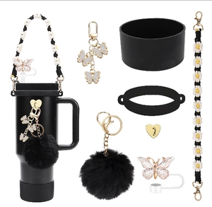 Detail view of black silicone tumbler accessories with daisy strap and butterfly charms