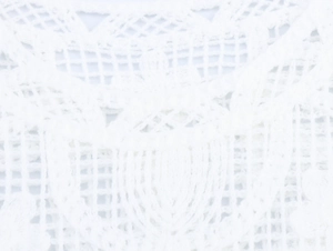 Dettaglio del gilet all'uncinetto in pizzo bianco con intricati motivi a maglia traforati