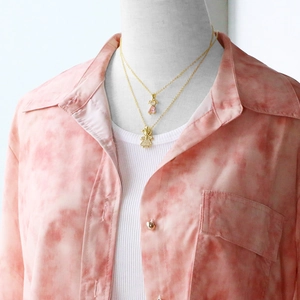 Detail of layered gold family necklace featuring a pink heart gem and crystal girl pendant
