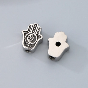 Macro shot of silver Hamsa Hand charms with retro moon and eye details for jewelry making