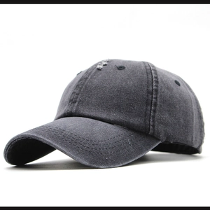 Dettaglio macro di un cappellino da baseball in denim grigio scuro con strappi vintage