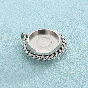 Detailed close-up of a silver stainless steel round pendant with twisted rope texture