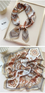 Detailed view of luxury vintage paisley silk scarf featuring rich orange and brown floral patterns