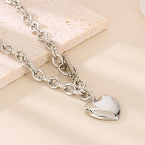 Détail du pendentif cœur et du fermoir à bascule OT sur le collier en acier argenté