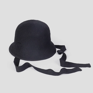 Détails du tissage d'un chapeau cloche au crochet noir avec de longs rubans élégants