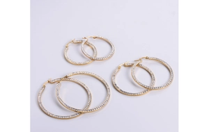 Detailed view of three pairs of gold-plated square hoop earrings with sparkling rhinestones