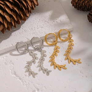 Elegant gold and silver willow leaf tassel earrings displayed on decorative stones